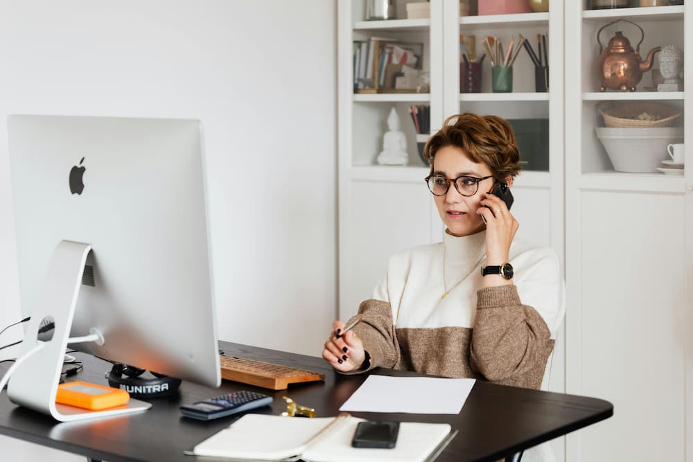Una persona sentada en un escritorio frente a una computadora