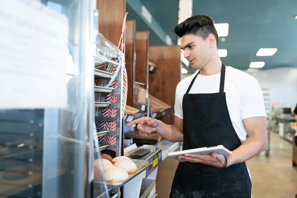 Profesional de panadería verificando la calidad de los alimentos preparados.