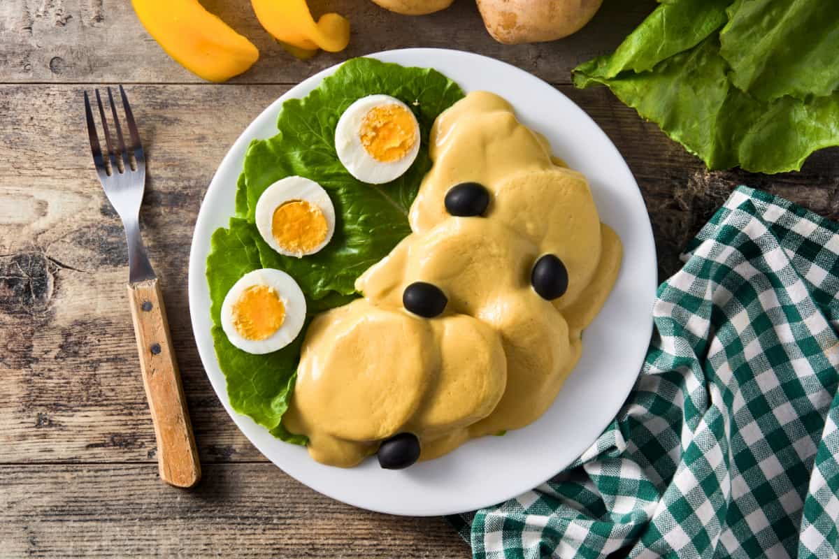 Plato típico con papas a la huancaína, huevo y aceitunas, ideal para recetas con papa para delivery.