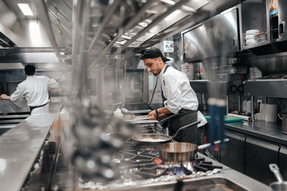 Cocineros trabajando en cocina industrial, representando la alta capacidad de producción para dark kitchen.
