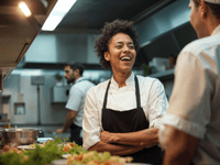 
A imagem captura uma cena de interação positiva e trabalho em equipe em uma cozinha profissional de alta qualidade.