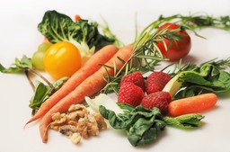 Variedade de vegetais e frutas frescas em um fundo branco, representando o crudivorismo.