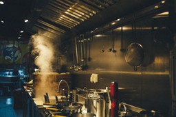 Cocina oculta con equipamiento. Hay sartenes, fogones, cucharas y otra maquinaria.