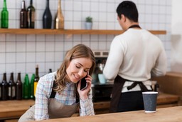 Barista interage com cliente em um café, exemplificando um bom relacionamento com o cliente.