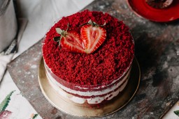 Bolo Red Velvet decorado com morangos frescos, perfeito para explorar sabores de bolo de aniversário com sofisticação e charme.