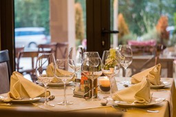 Mesa de restaurante elegantemente posta com taças e guardanapos dobrados, destacando-se como diferencial competitivo na experiência gastronômica.