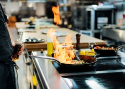 Chef con una sartén al fuego.
