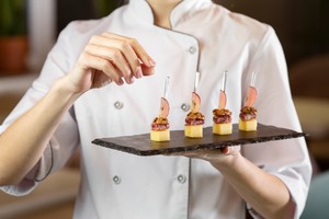 Chef presentando aperitivos gourmet; ejemplo ideal para estrategias de marketing digital para catering atractivo y profesional.