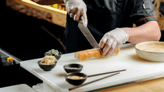 Esta imagem foca em um chef jovem e focado em sua tarefa, preparando sushi.