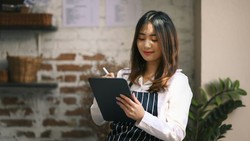 Profissional utilizando tablet com sorriso, em ambiente moderno e descontraído