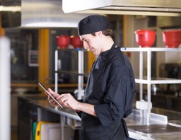 O que é smart kitchen: chef de cozinha com um tablet nas mãos.