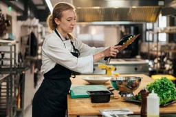 Chef trabalhando em uma dark kitchen moderna, destacando o preparo de alimentos, sugerindo o contexto de aluguel de dark kitchen.