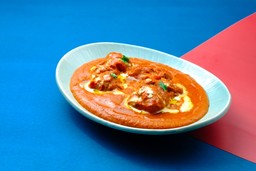 Comida indiana: Curry indiano Masala com frango, legumes e especiarias em um molho cremoso, servido em uma tigela rústica.
