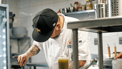 Esta imagem captura um chef focado e ocupado em uma cozinha profissional.