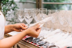 Preparación de cubiertos para evento elegante; organización y detalle son claves en cómo expandir tu negocio de catering.