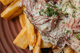 Prato com mandioca frita e carne desfiada, exemplo de como criar um cardápio personalizado por região do Brasil.