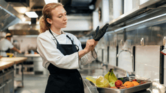 Esta imagem foca em uma cozinheira jovem e focada em sua tarefa.