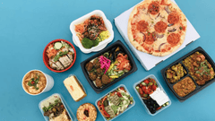 Esta última imagem apresenta uma visão aérea de uma diversidade gastronômica completa, ideal para ilustrar serviços de entrega (delivery), catering corporativo ou a variedade de opções de alimentação moderna.