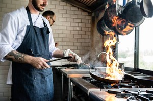 Cocineros trabajando en cocina profesional, ilustrando los desafíos de cómo abrir un restaurante en Chile.
