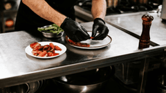 imagen nos traslada al "detrás de escena", mostrando el proceso de preparación y emplatado en una cocina profesional.