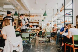 Clientes desfrutando de um café movimentado, enfatizando a importância de um programa de fidelidade para aumentar a lealdade no restaurante.