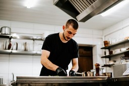 Cozinheiro preparando refeição em cozinha profissional, mostrando as vantagens de abrir uma dark kitchen em Santo Amaro.