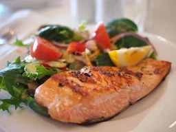 comida saudável em prato com salmão, salada verde e tomate